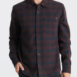 Man wearing a plaid shirt on a plain background