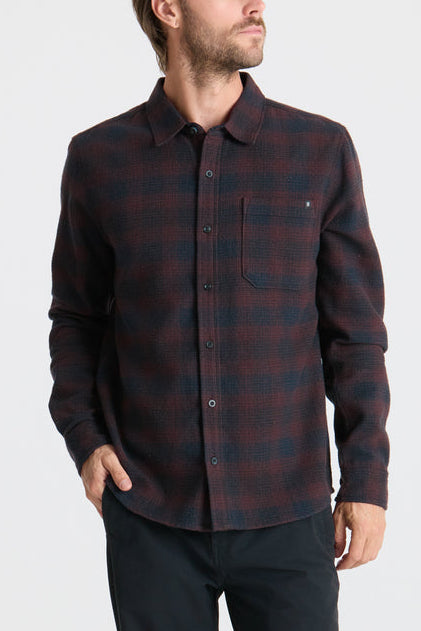 Man wearing a plaid shirt on a plain background