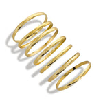 Seven gold bangles stacked on the wrist