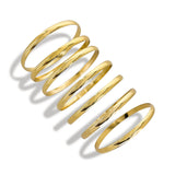 Seven gold bangles stacked on the wrist
