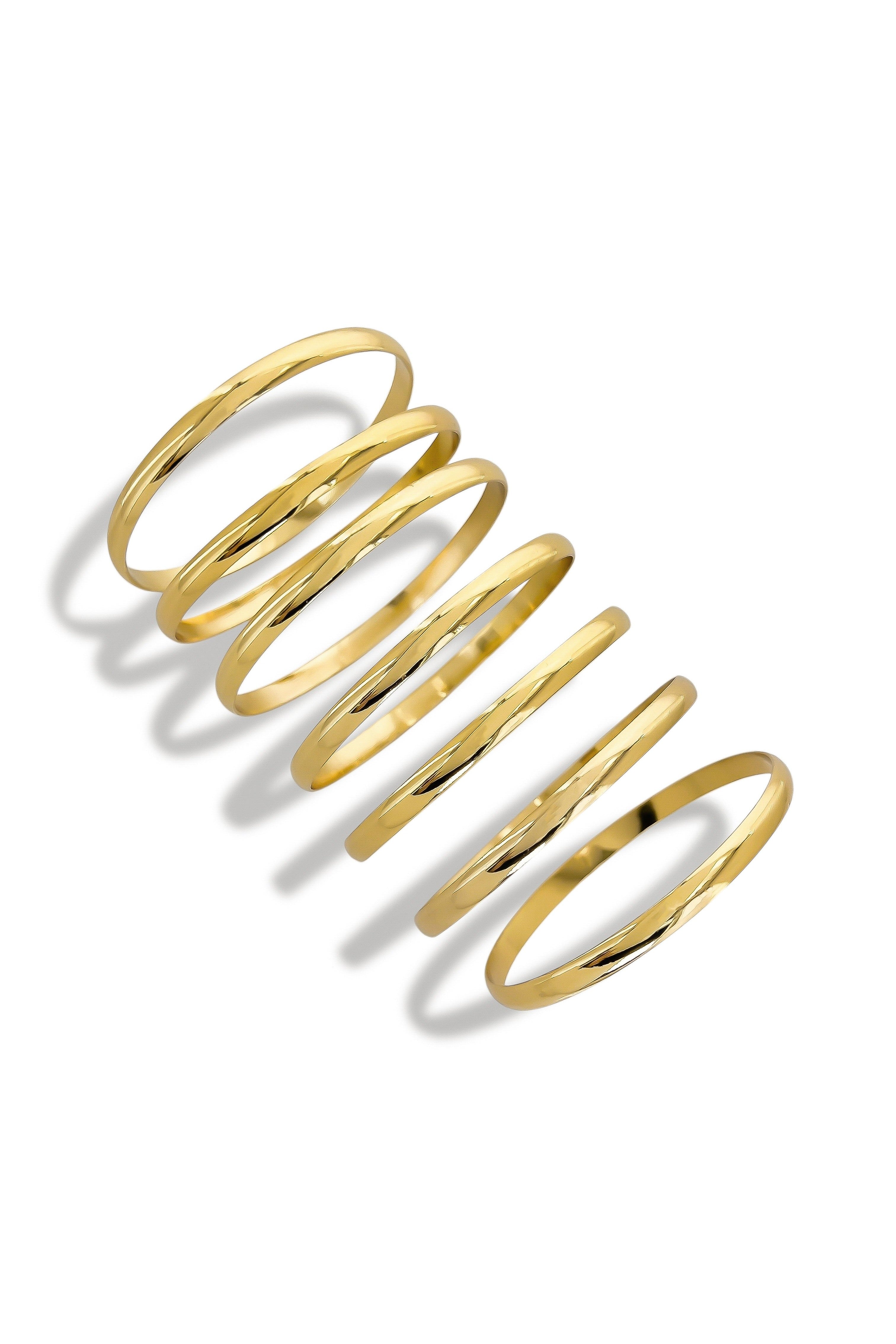 Seven gold bangles stacked on the wrist
