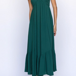 Green halter neck dress with ruffled hem on a white background