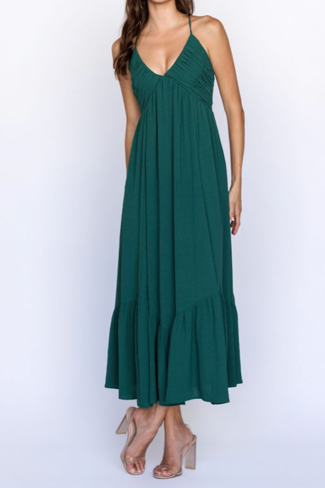 Green halter neck dress with ruffled hem on a white background