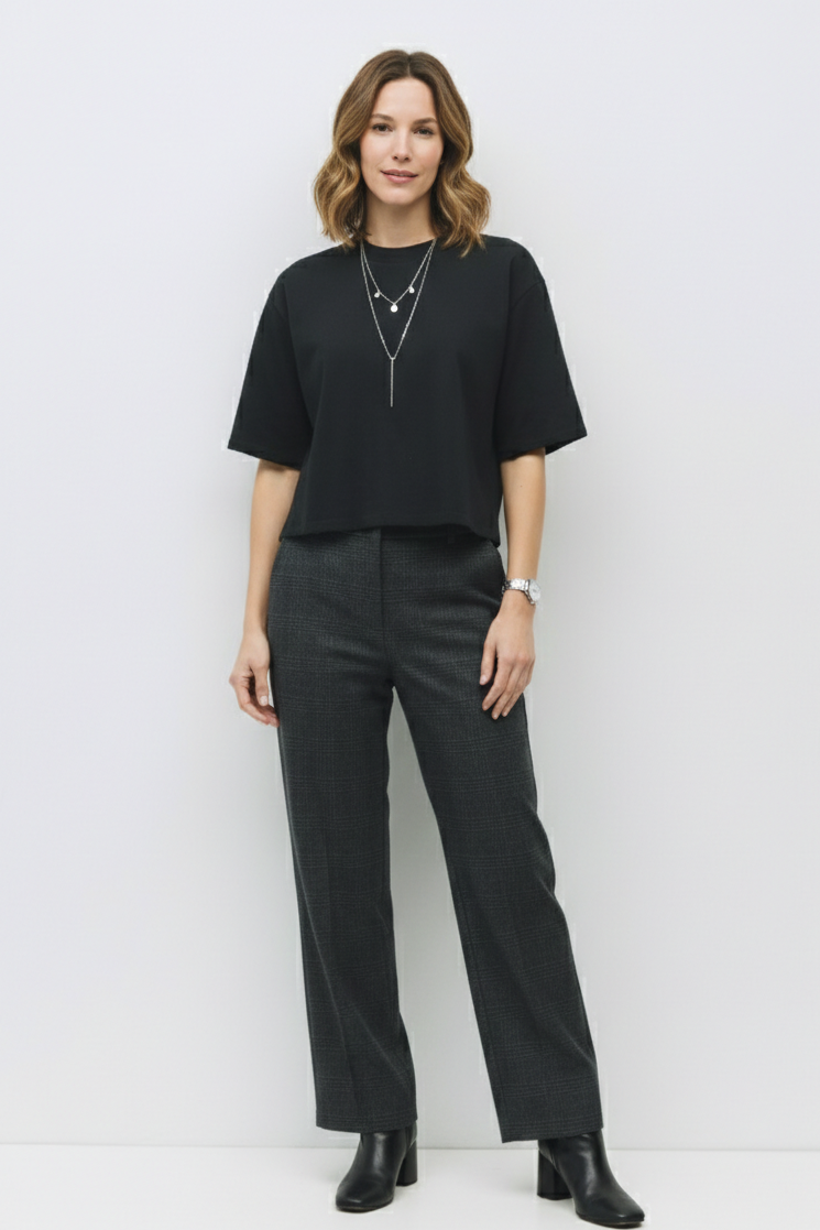 Woman wearing a black outfit with a plain white background