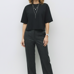 Woman wearing a black outfit with a plain white background