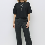 Woman wearing a black outfit with a plain white background