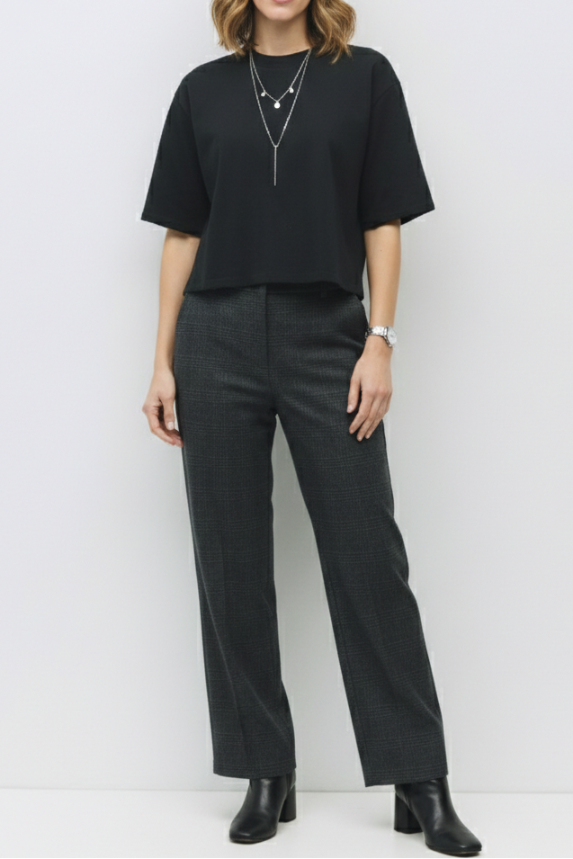 Woman wearing a black outfit with a plain white background