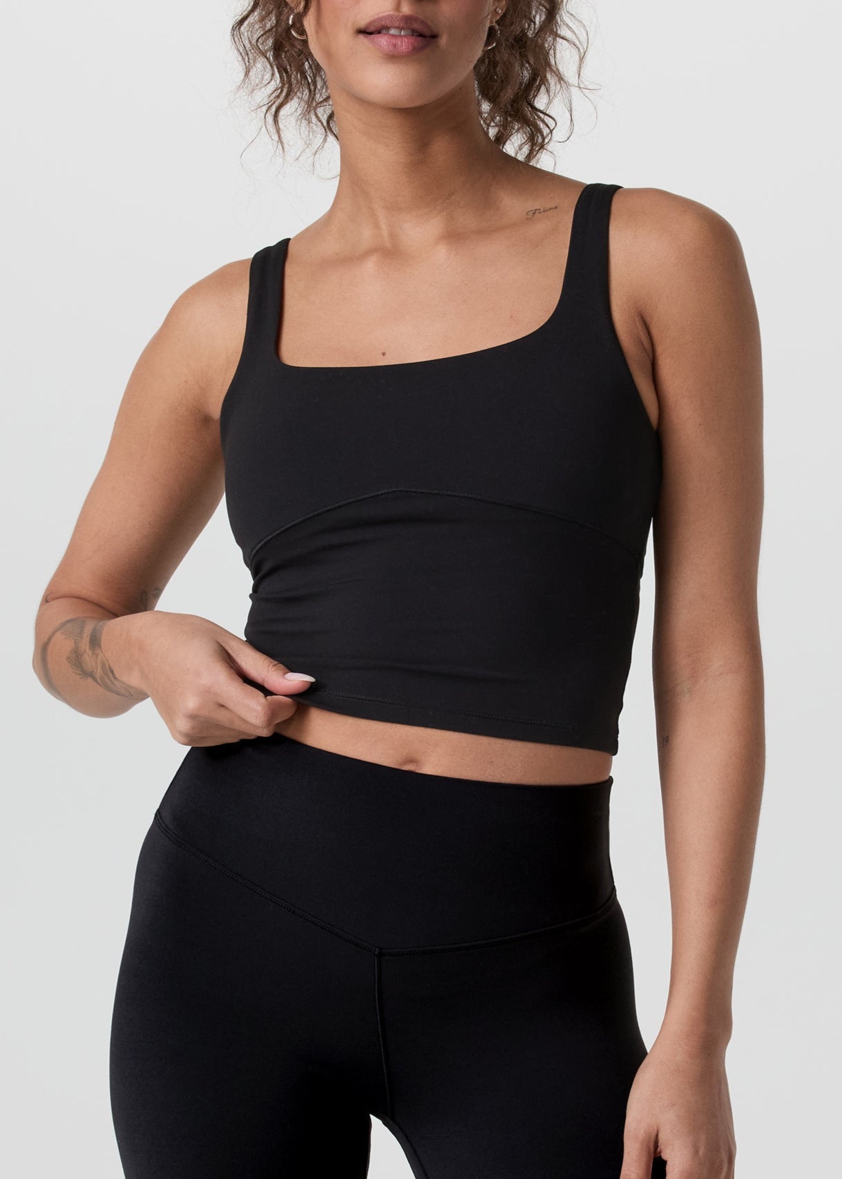 Woman wearing a black athletic outfit on a white background