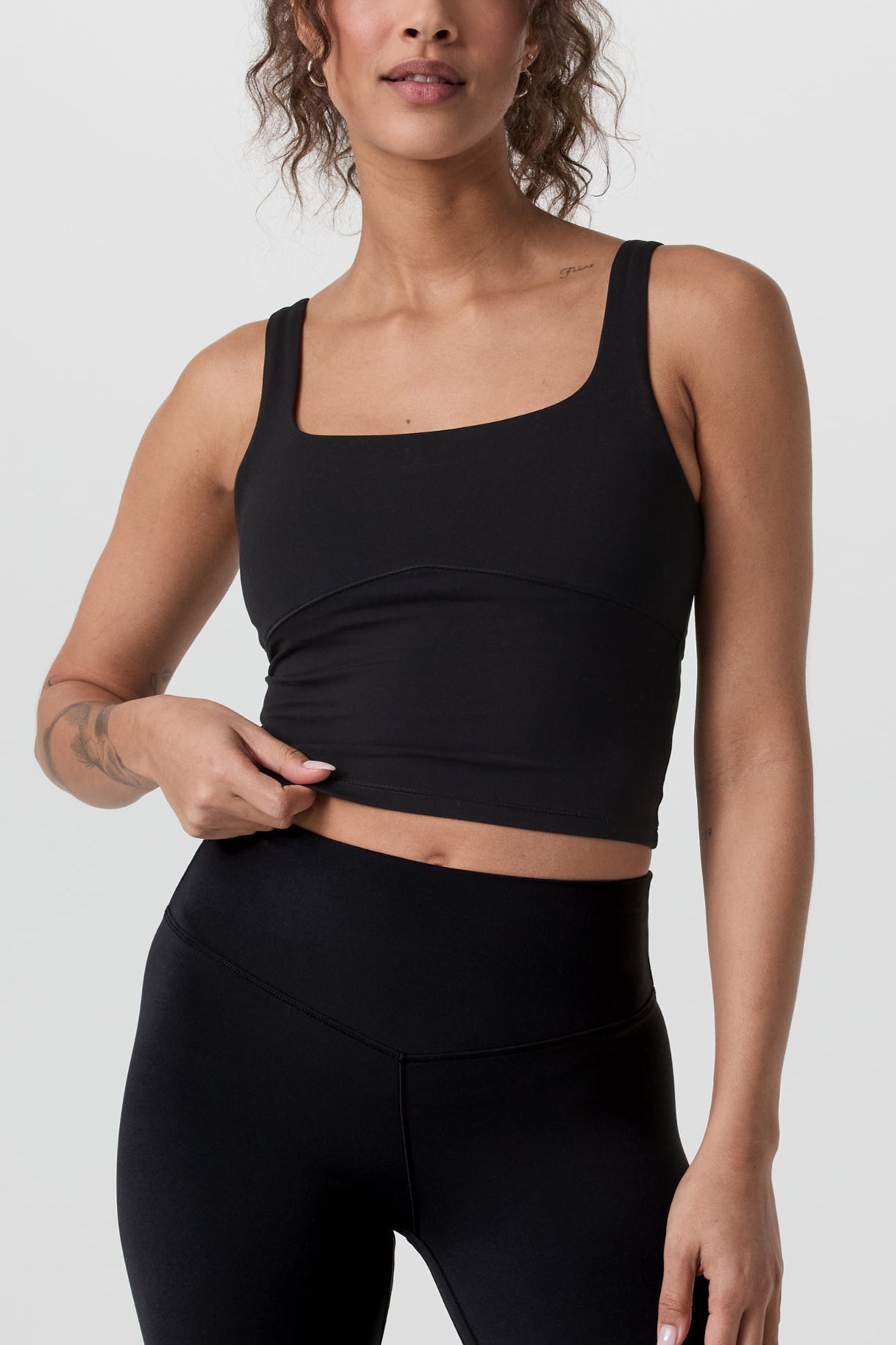 Woman wearing a black athletic outfit on a white background