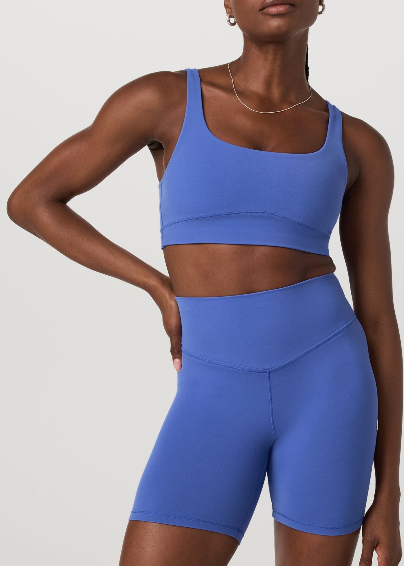 Woman wearing a blue athletic outfit on a light gray background