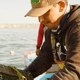 Man wearing the Seager Wilson Waxed Canvas Snapback in Tan on the water