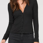 Woman wearing a black long-sleeve top against a white background