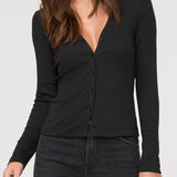 Woman wearing a black long-sleeve top against a white background