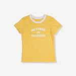 Yellow baby tee with white trim and 'RETIREE IN TRAINING' text on front