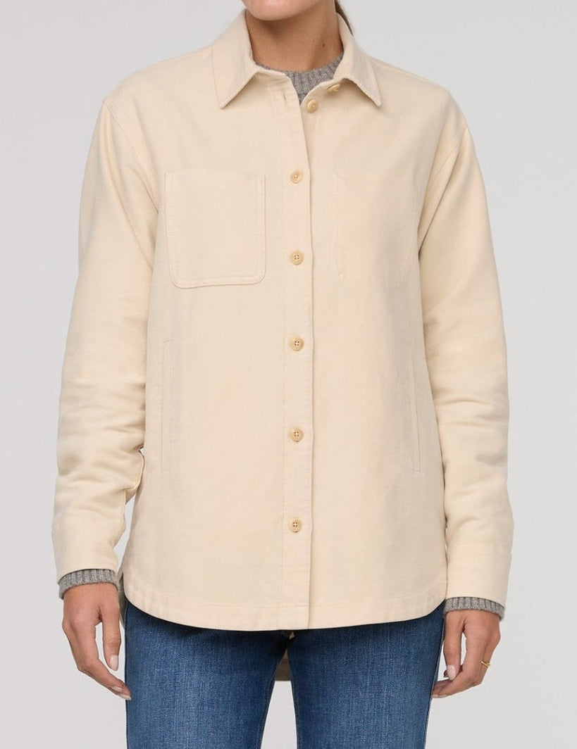 Beige button-up shirt worn by a person on a plain background