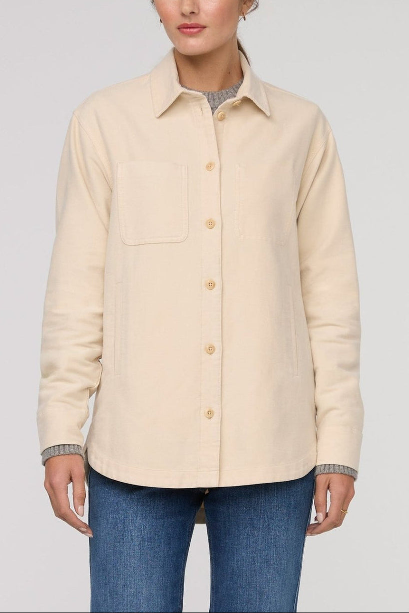 Beige button-up shirt worn by a person on a plain background