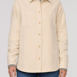 Beige button-up shirt worn by a person on a plain background