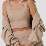 Woman wearing a beige outfit with a plain background