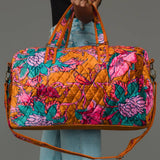 Wildflower Woven Duffel in burnt orange floral, carried