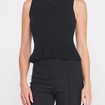 Woman wearing a black sleeveless top with a peplum waist on a white background