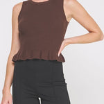 Woman wearing a brown sleeveless top and black pants on a white background