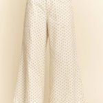 White pants with black polka dots on a beige background