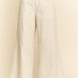 White pants with black polka dots on a beige background