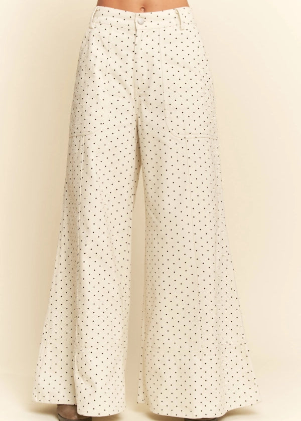 White pants with black polka dots on a beige background