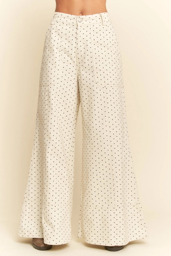 White pants with black polka dots on a beige background