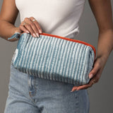 Juniper Velvet Ribbed Pouch in light blue and orange, held