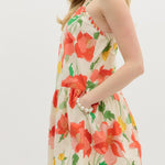 Woman wearing a floral dress with red flowers on a white background