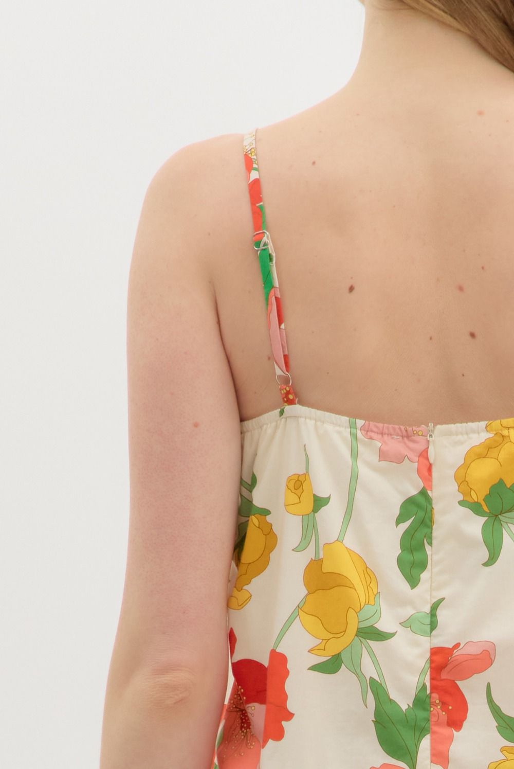 Floral dress with colorful straps on a plain background