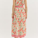Woman wearing a floral dress with red accents on a white background