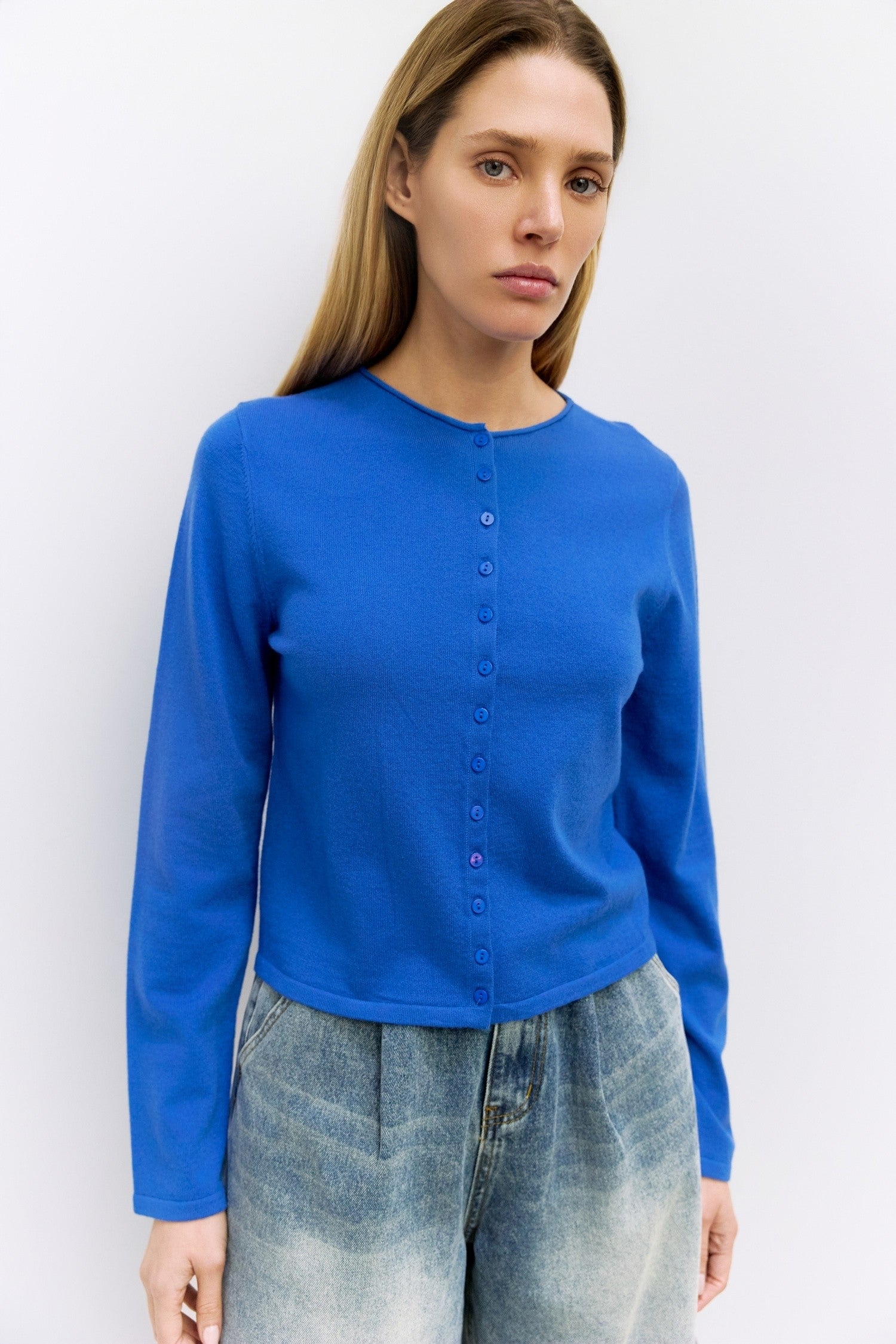 Cambria Rolled Neck Cardigan in blue, detail of rolled neckline and button front